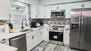 A modern kitchen with white cabinets, a stainless steel refrigerator, a built-in microwave, and a dishwasher. - Spacious & beautiful 4-bedroom in a peaceful Severn, close to DC & Baltimore (Severn)
