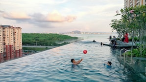 An outdoor swimming pool with a view of a cityscape and a river.