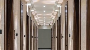 A long, narrow hallway with doors on both sides, leading to a room at the end. - Hotel Kingsway Continental Raipur (Raipur)