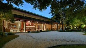 A traditional-style building with a spacious outdoor area, a gravel driveway, and a well-maintained garden.