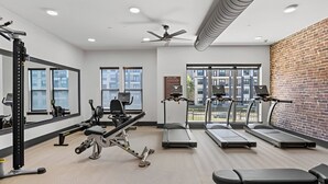 A gym with treadmills, weight machines, and a bench. - Lux King Suite | Pool | Gym | By Domain Mall | TechRidge (Austin)