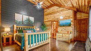 Une chambre de style cabane avec un lit en bois, un banc et un ventilateur de plafond.
