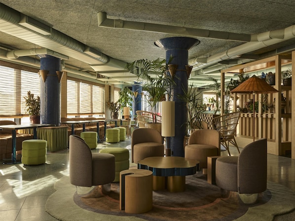A spacious lobby with high ceilings, large columns, and a variety of seating arrangements.