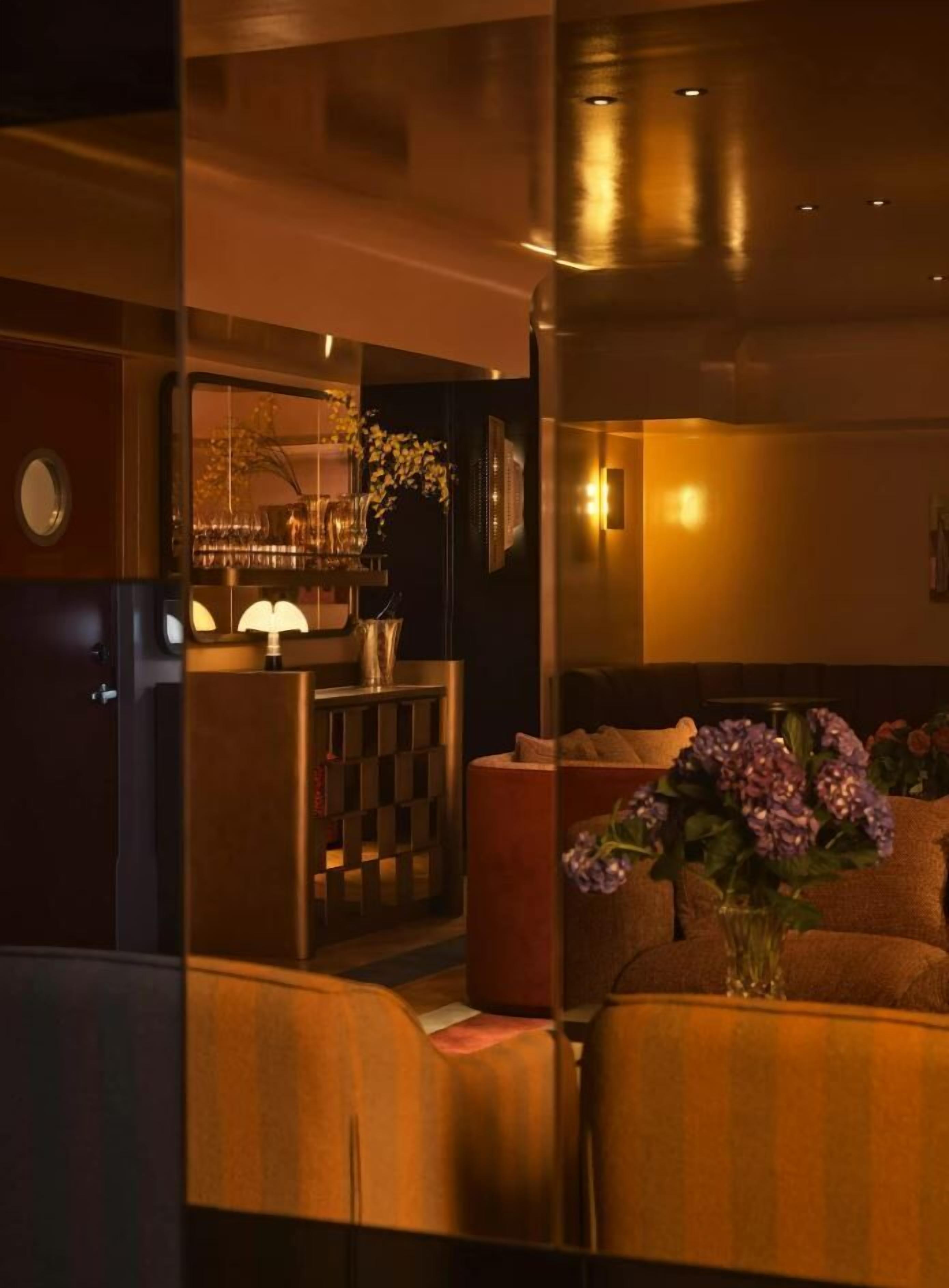 A modern interior with a bar area, seating, and a decorative vase.
