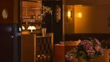 Un interior moderno con zona de bar, asientos y un jarrón decorativo.