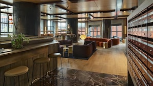 A modern interior with a bar area, seating, and storage lockers. - Hannah St Hotel Melbourne (Southbank)