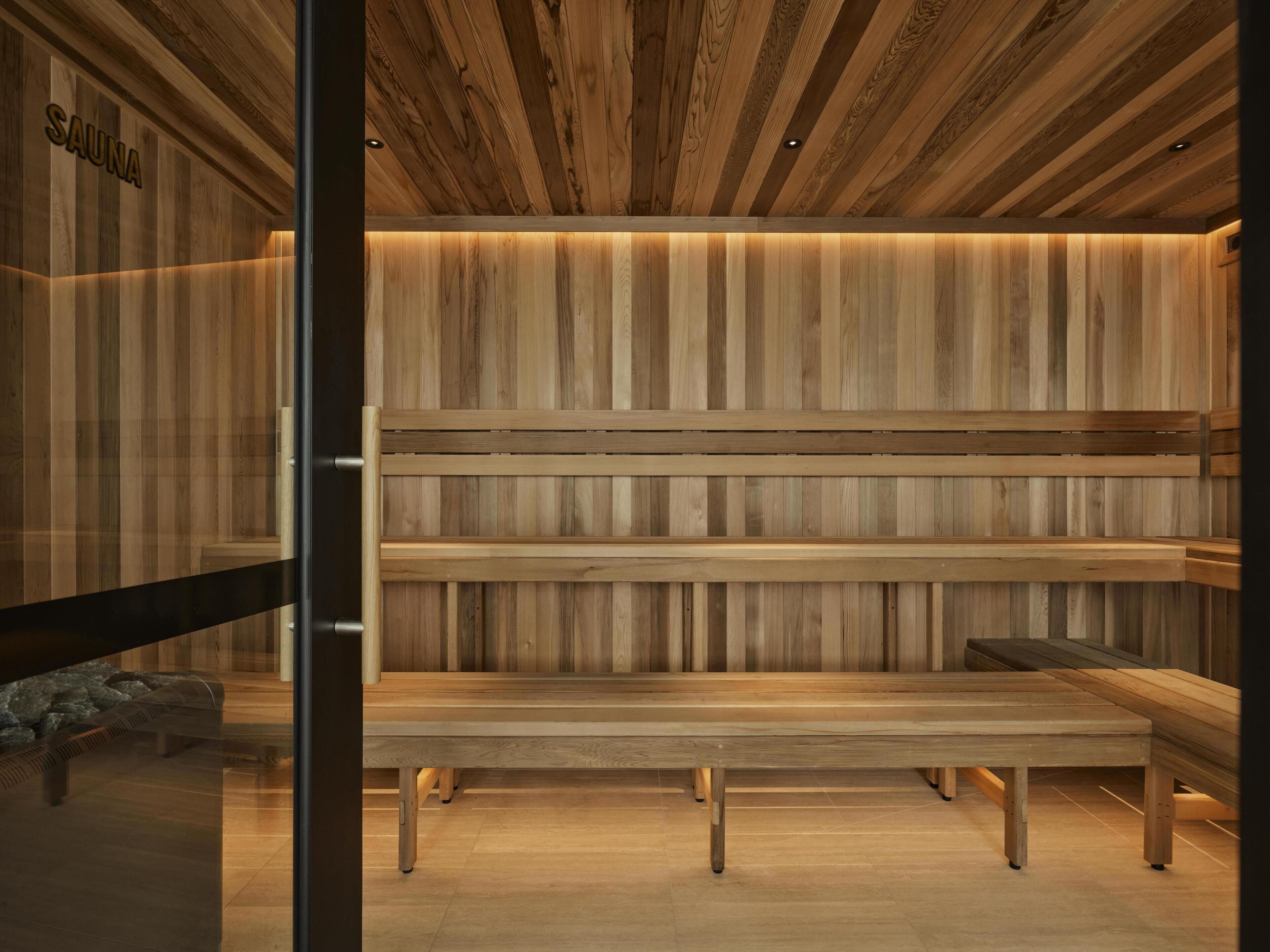 A sauna with wooden benches and a sloped ceiling.