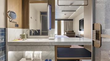 A modern bathroom with a vanity, mirror, and towel rack.