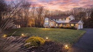 A two-story house with a front porch, a driveway, and a well-maintained lawn.