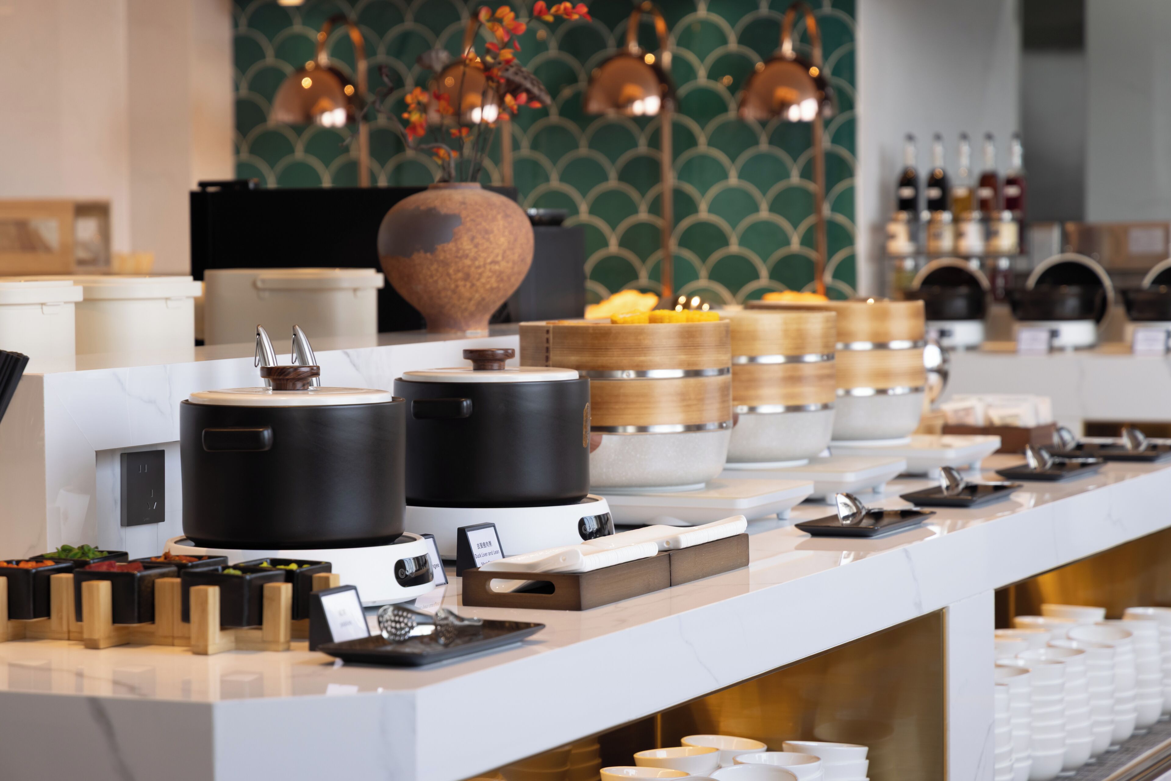 A buffet setup with various food containers and serving utensils.