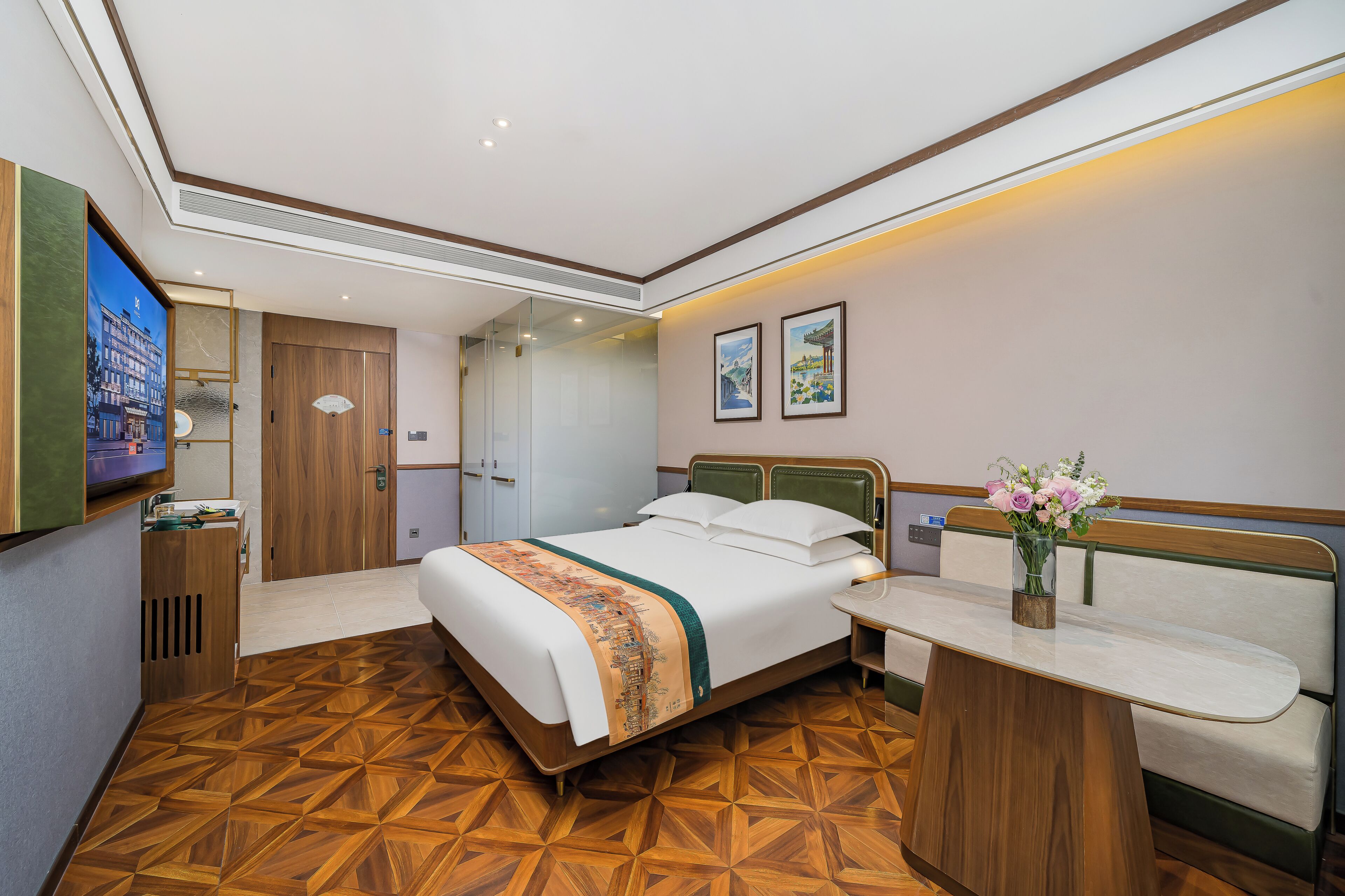 Ein Hotelzimmer mit Bett, Schreibtisch, Stuhl, Fernseher und einem Wandbild.