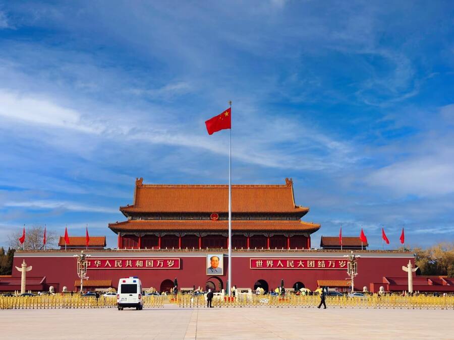 Ein traditionelles chinesisches Gebäude mit rotem Dach und einer Fahnenstange mit einer roten Flagge.
