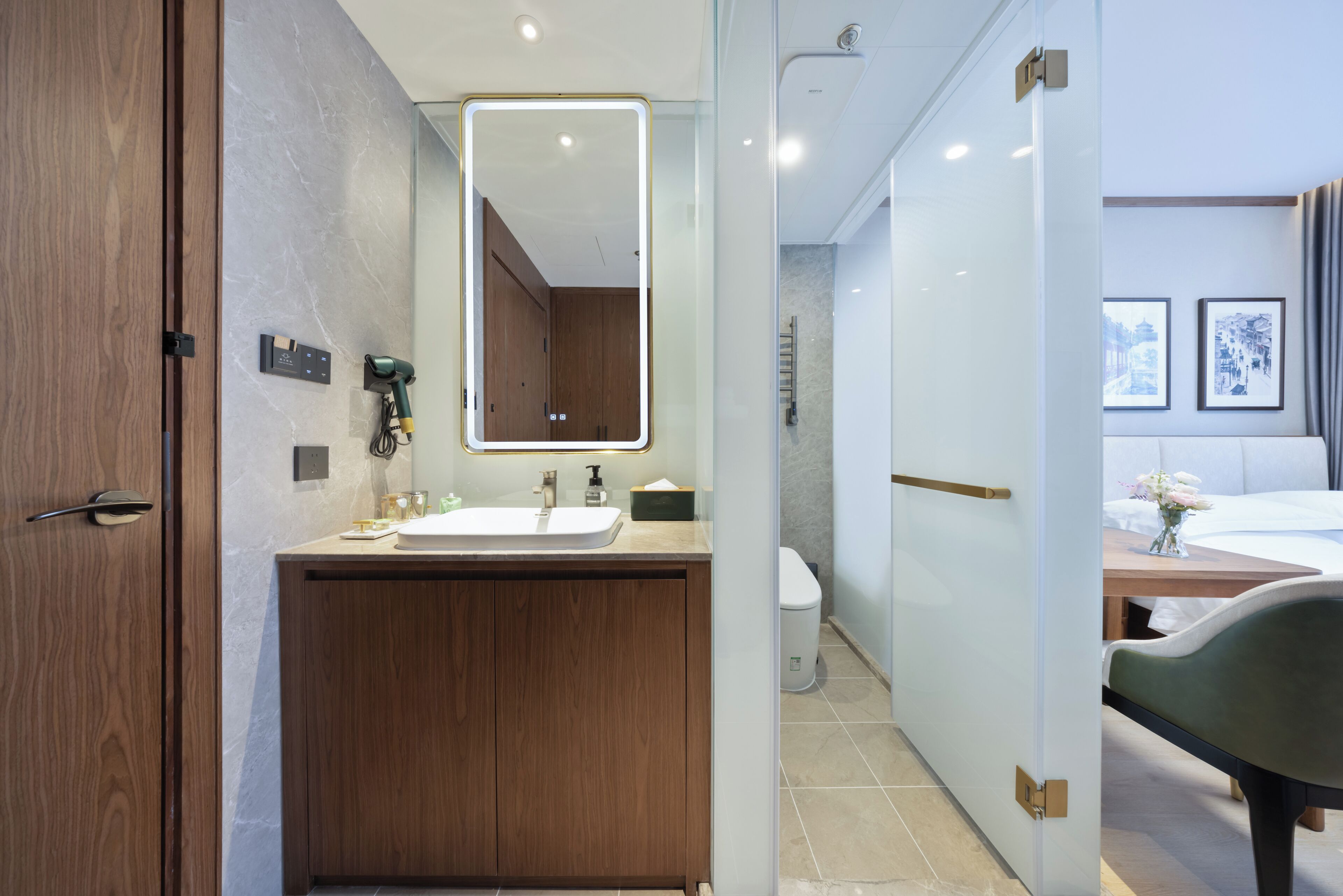 Et moderne badeværelse med en trækommode, et stort spejl og et toilet.