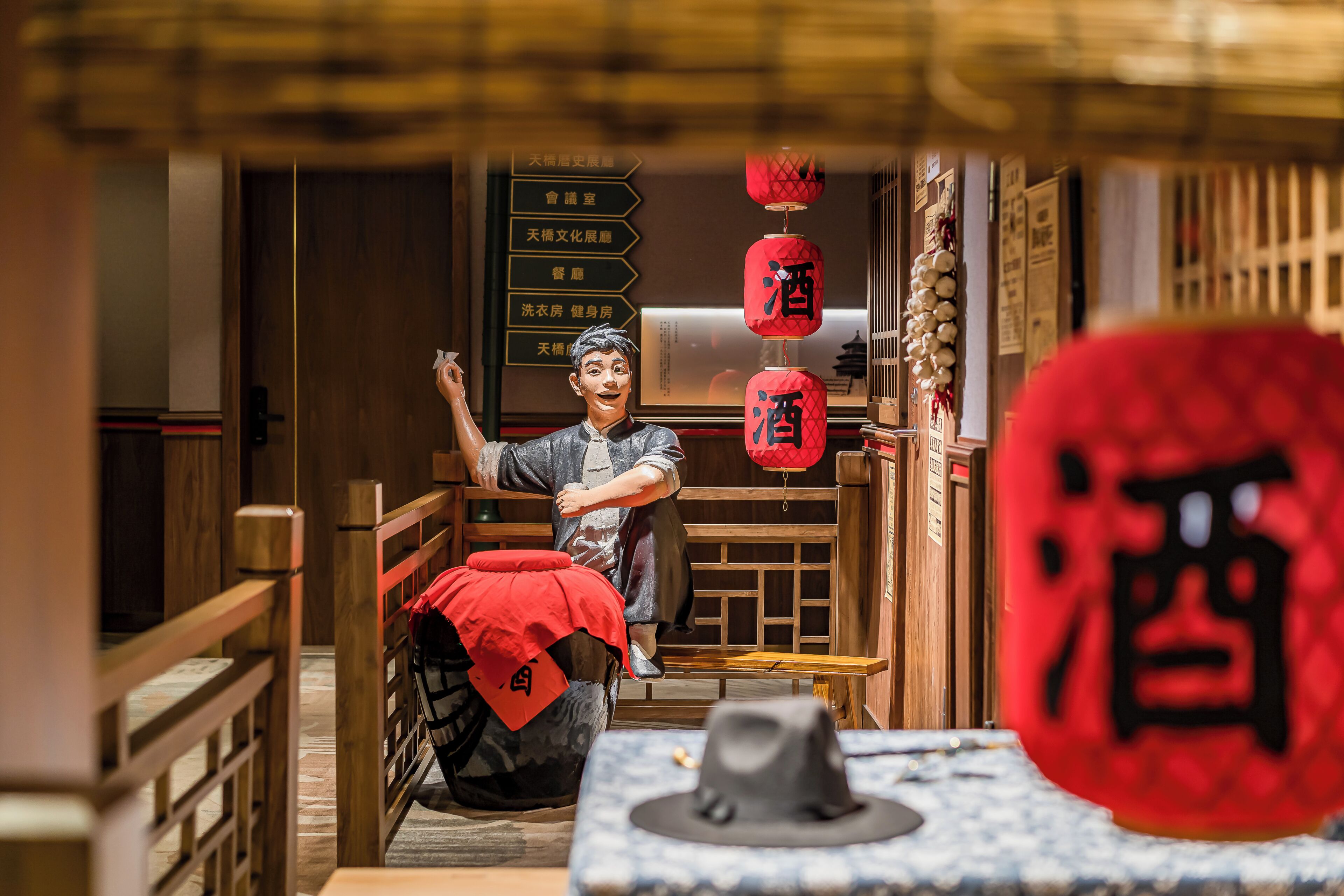 A traditional Chinese interior with wooden furniture, a red lantern, and a sign with Chinese characters.