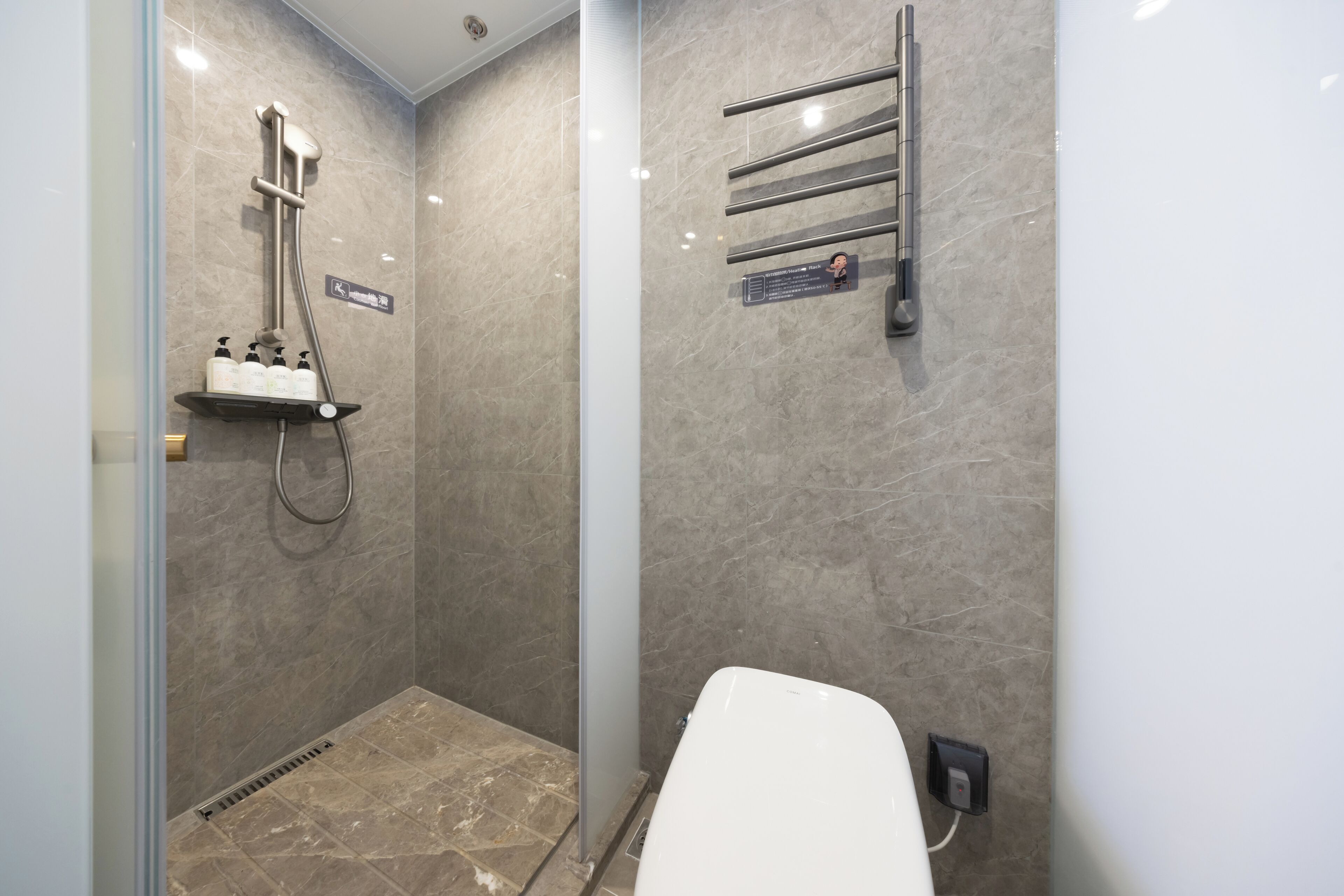 Un baño moderno con ducha, inodoro y barra para toallas.
