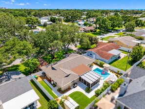 A residential area with houses, a swimming pool, and a clear view of the ocean.