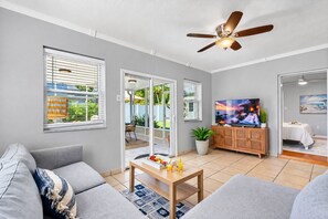 A modern living room with a grey sofa, a wooden coffee table, and a television.