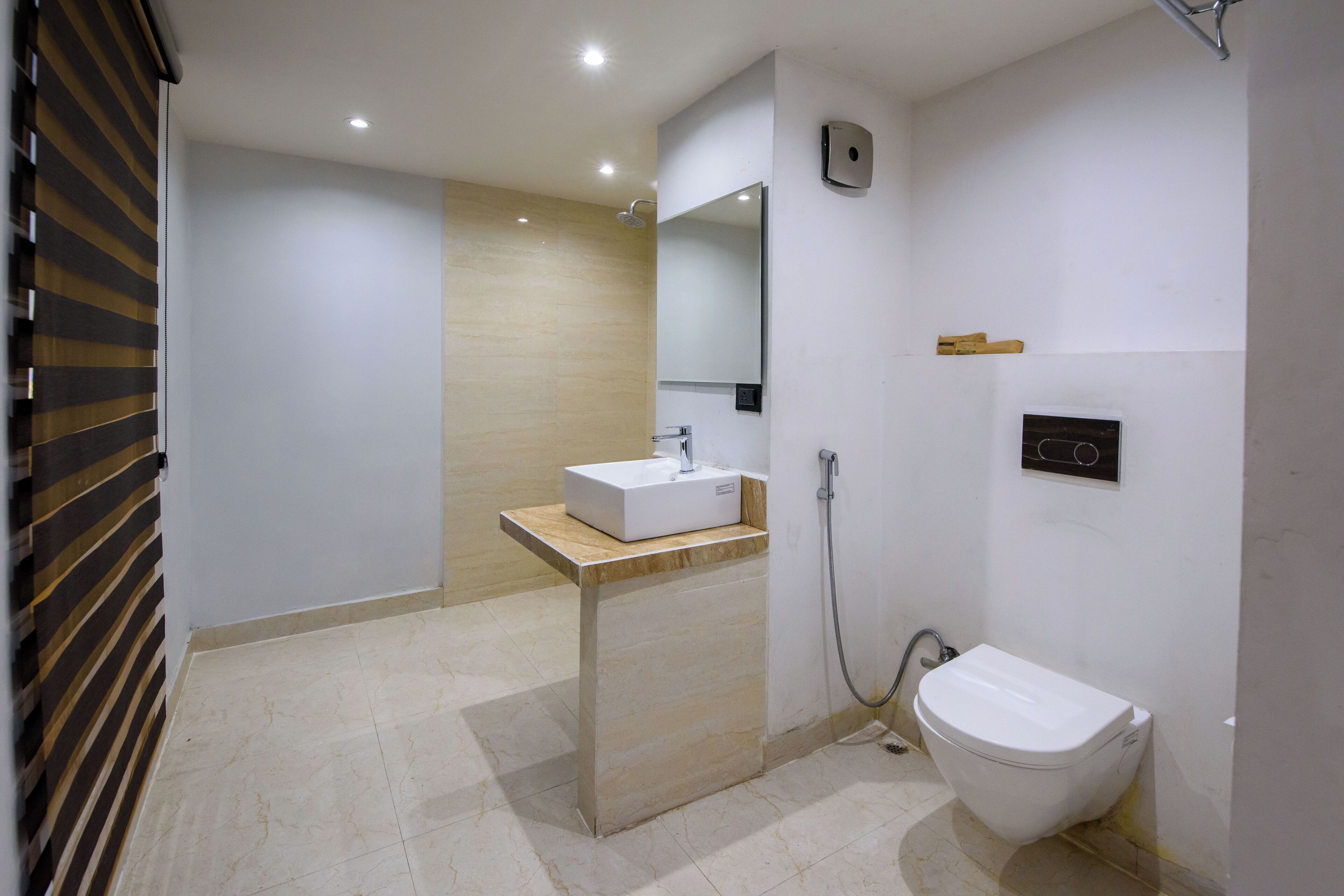 A modern bathroom with a white sink, a toilet, and a shower.