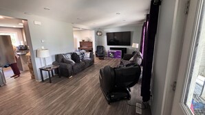 Ein modernes Wohnzimmer mit einer Couch, einem Fernseher und einem Klavier.
