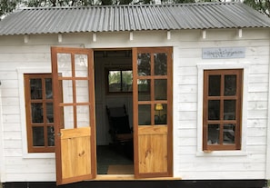 A small white wooden structure with a corrugated metal roof, a sign reading 'Peppercorn Summerhouse,' and a wooden door leading inside. - Peppercorn Cottage Avoca ... Colonial cottage accommodation on the Avoca River (Avoca)