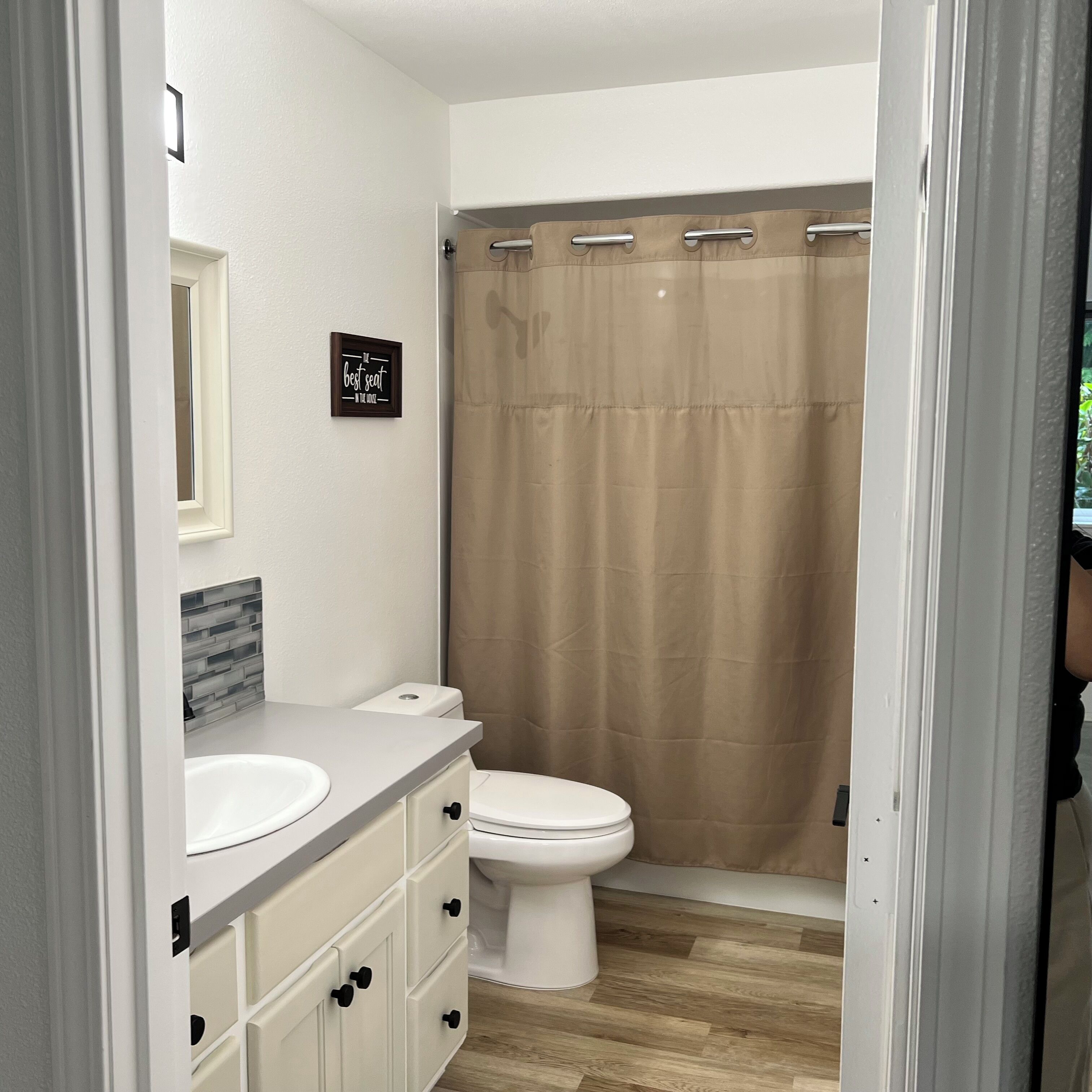 A bathroom with a toilet, a sink, and a shower curtain.