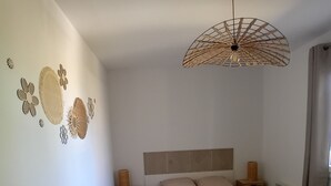 A bedroom with a bed, nightstands, a wall-mounted light fixture, and decorative wall art. - House Des 3 filles in cantal 15700 (Ally)