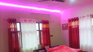 Un dormitorio con cama, cortinas, ventana y ventilador de techo.