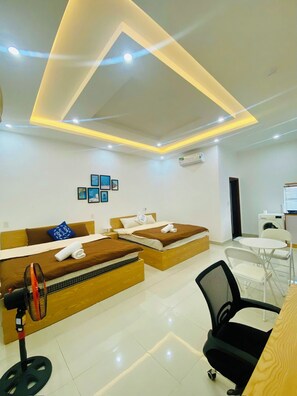 A hotel room with two beds, a desk, a chair, and a washing machine. - Lavi home (Da Nang)
