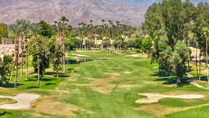 A golf course with a clear path, sand bunkers, and a backdrop of mountains. - Golf View Retreat w/ Sunset Patio, Media Room, Fireplace & Pool/Spa Steps Away (Palm Desert)