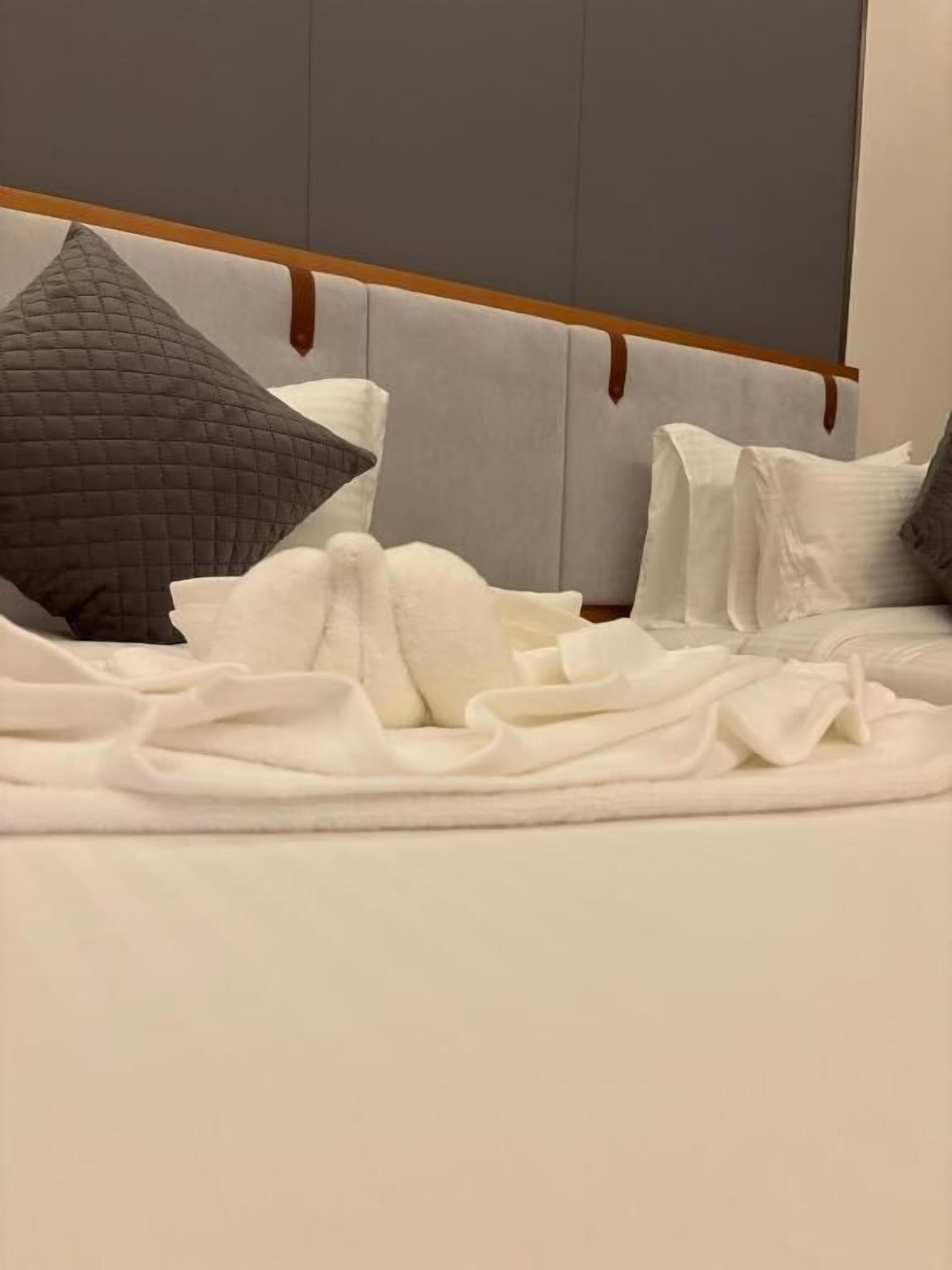 A bed with a headboard, pillows, and a blanket.