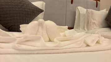 A bed with a headboard, pillows, and a blanket.