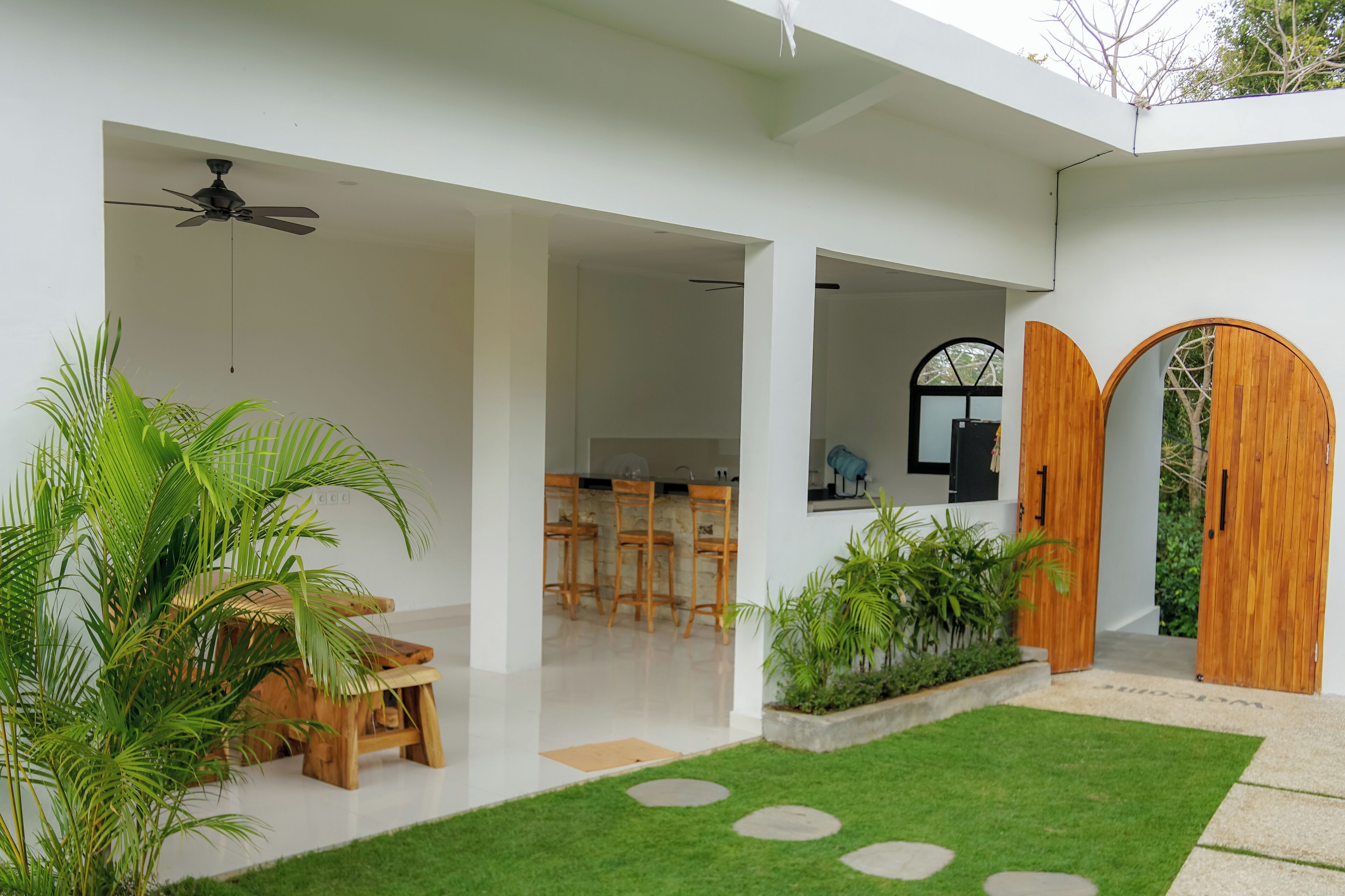 A modern interior with a dining area, wooden doors, and a ceiling fan.