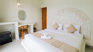 Une chambre d’hôtel bien aménagée, avec un grand lit, un bureau et une chaise.