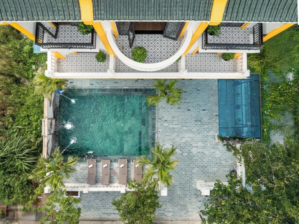 An aerial view of a hotel with a swimming pool, sun loungers, and a covered area with a railing. - Tam Coc Babylon Hotel (Hoa Lu)