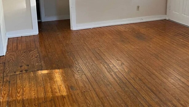 A room with wooden flooring, white walls, and a ceiling fan. - Charming 2-bedroom house in lovely Columbia with AC/ WiFi and smart tv. Backyard (Columbia)