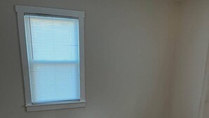 A room with a large window, wooden flooring, and white walls. - Charming 2-bedroom house in lovely Columbia with AC/ WiFi and smart tv. Backyard (Columbia)