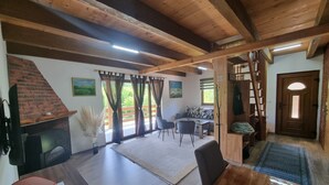 Un amplio salón con chimenea, una mesa de comedor y un sofá.