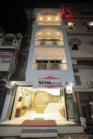 A hotel entrance with a reception desk, a waiting area with seating, and a sign reading 'NEHA PALACE'. - Hotel Neha Palace (Ujjain)