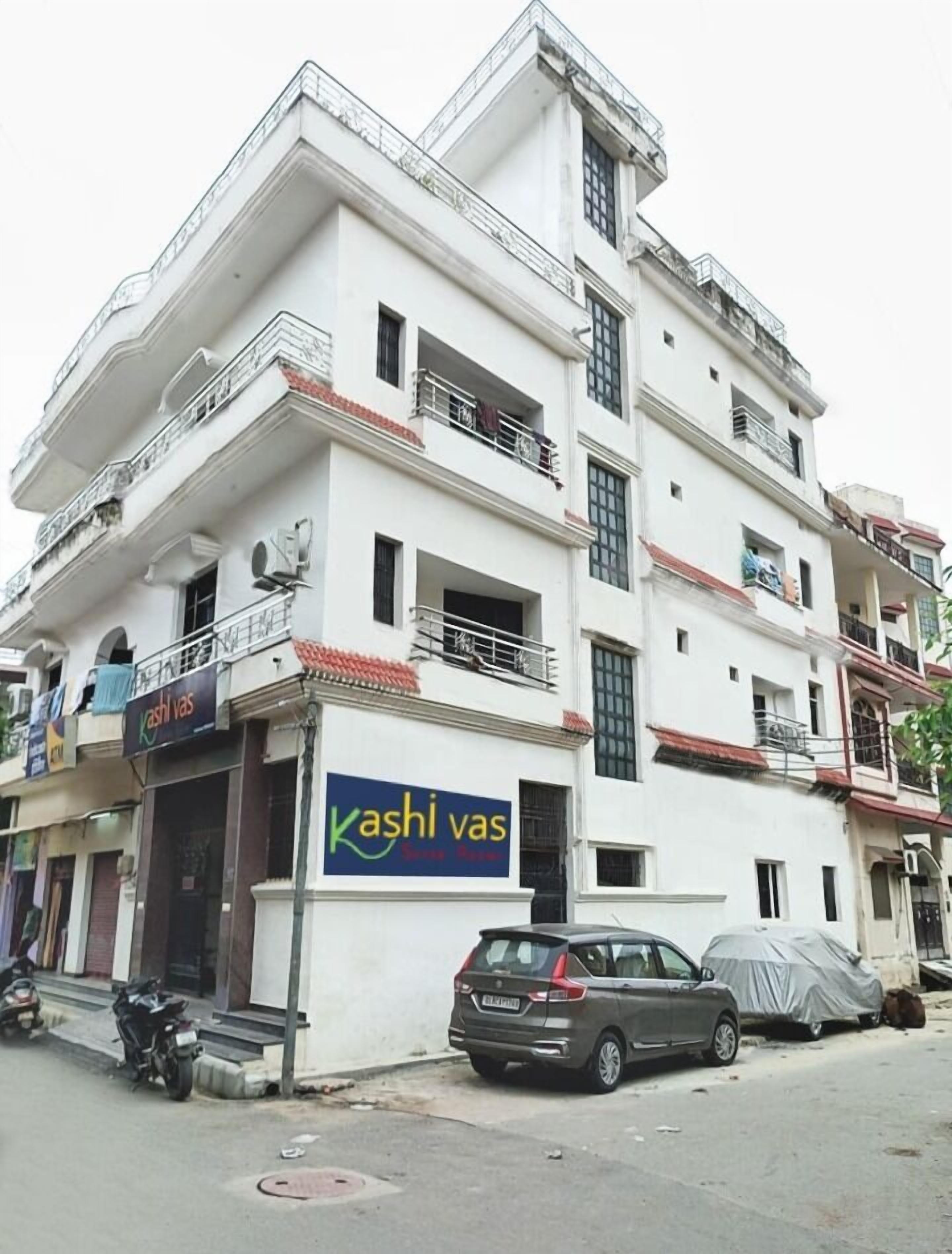 A multi-story building with a sign for 'Kashi vas' on the ground floor.