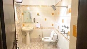 A bathroom with a sink, toilet, and mirror. - Kashi Vas Super Rooms (Varanasi)