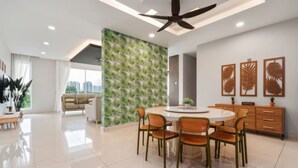 A modern dining area with a round table and chairs, a ceiling fan, and a wall with a leaf pattern. - The Embassy Row 206 Apartments (Kuala Lumpur)