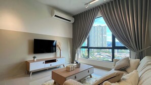 A modern living room with a flat-screen TV, a wooden coffee table, and a large window with curtains. - Aradia Residence Lake City KL North (Kuala Lumpur)