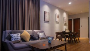 Ein modernes Wohnzimmer mit Sofa, Couchtisch und Essbereich.