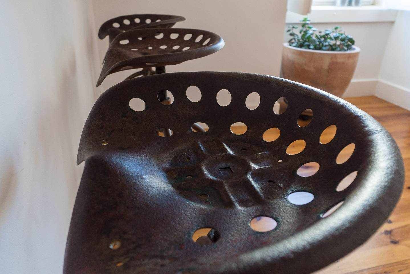 Ein Detailaufnahme eines schwarzen Metallteils mit mehreren kreisförmigen Löchern, möglicherweise ein Bestandteil einer größeren Konstruktion.