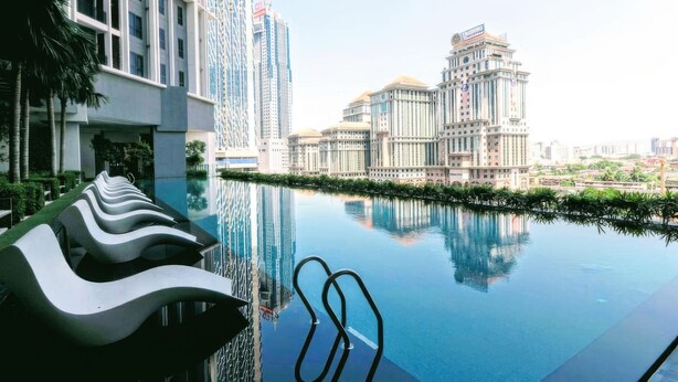 Ein modernes Hotel mit einem gläsernen Pool, zeitgenössischer Architektur und einem gepflegten Garten.