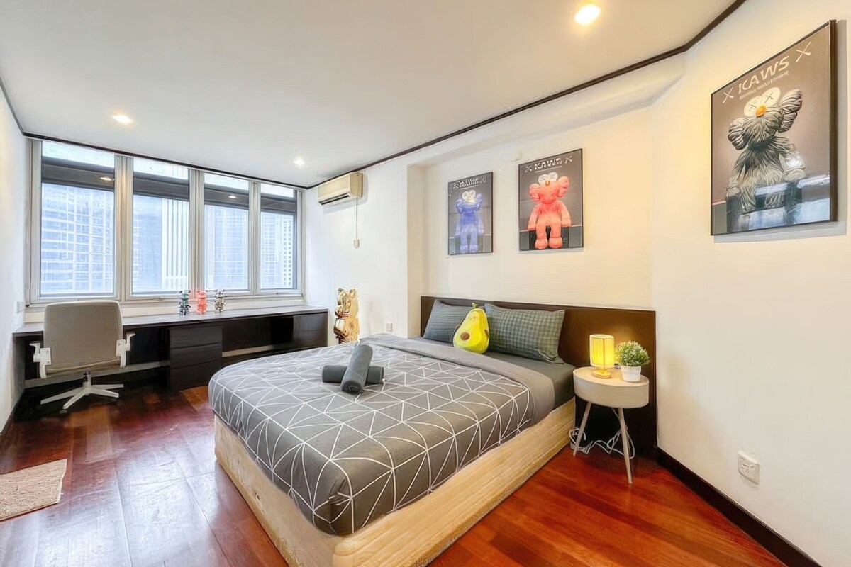 Une chambre à coucher moderne avec un grand lit, un bureau et une fenêtre.
