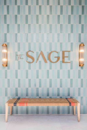 Una pared con un estampado de cuadros y la palabra "SAGE" en letras doradas.
