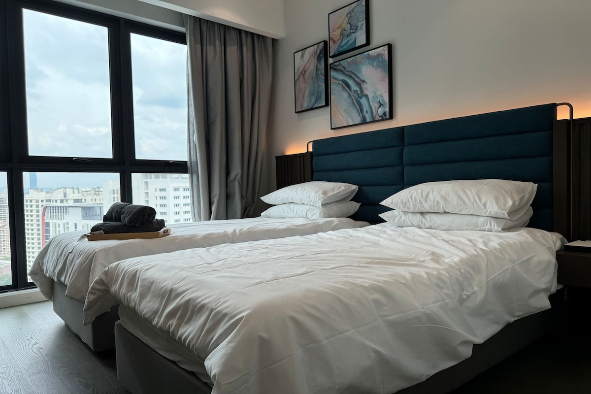 Een hotelkamer met twee bedden, een groot raam en kunst aan de muur.