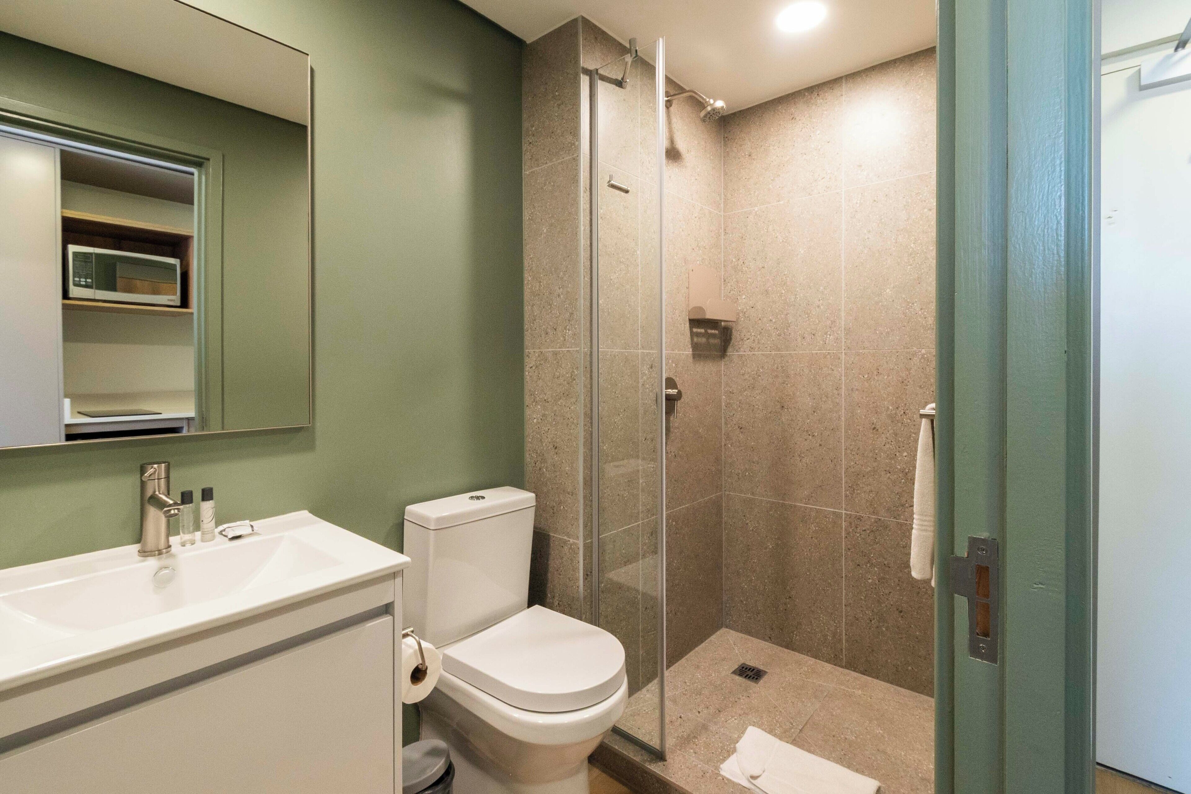 A bathroom with a sink, toilet, and glass-enclosed shower.