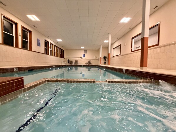 An indoor swimming pool with clear lanes, tiled walls, and a tiled floor.